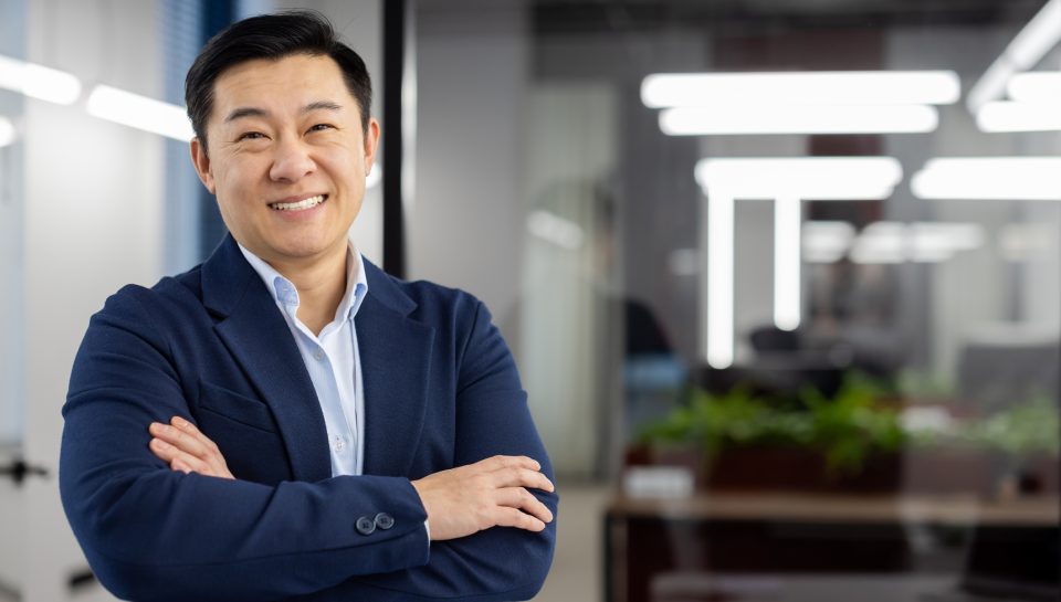 Portrait of successful asian businessman inside office at workplace, man in business suit smiling looking at camera, mature boss with crossed arms, successful financier broker.
